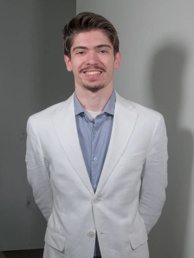 Andrew Neal wearing a white sports jacket, smiling